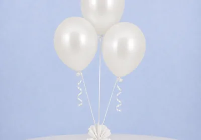 Three white balloons with sticks and cups, ideal for enhancing the festive atmosphere of any celebration or event.