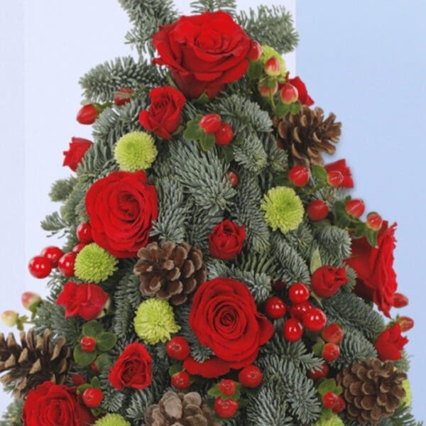 Merry Mini-Christmas tree A Christmas tree-shaped floral arrangement in a black pot. The arrangement features red roses, green foliage, pine cones, and berries.