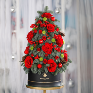 The image shows a beautiful and unique Christmas tree made entirely of flowers and greenery. The arrangement features: