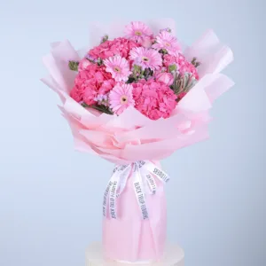 pink flowers is wrapped in light pink paper and tied with a white ribbon that says "BLACK TULIP FLOWERS" repeatedly