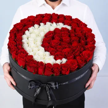 Luxurious black box with red and white roses in a crescent moon design.