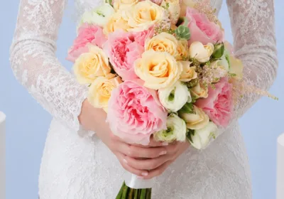 Dreamy Blush Wedding Bouquet featuring pink roses, peach spray roses, white ranunculus, and blush astilbe in a romantic bridal arrangement