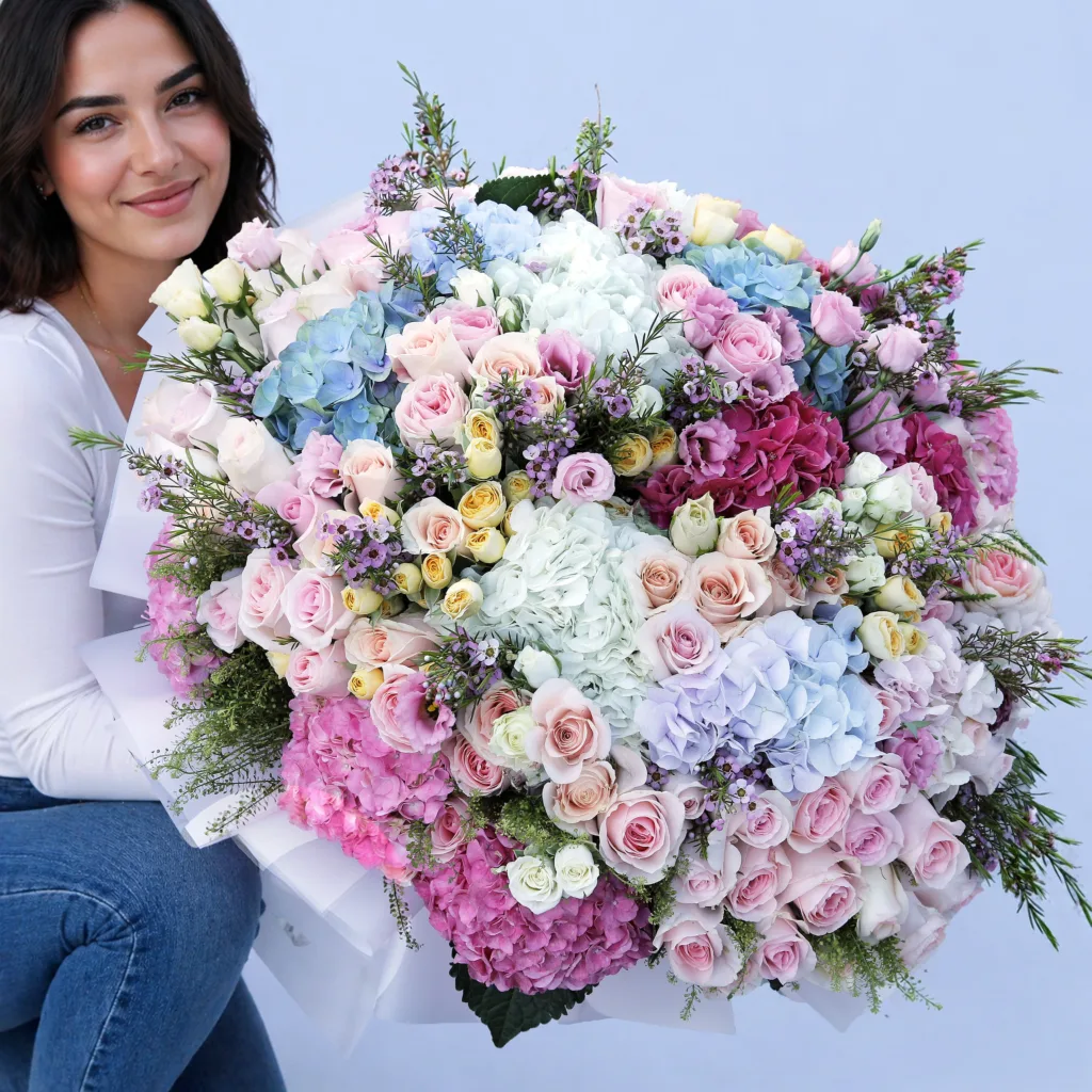 Floral Symphony Mixed Bouquet featuring hydrangeas in multiple colors, sweet revival roses, spray roses, wax flowers, and lisianthus arranged in a vibrant floral design