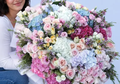 Floral Symphony Mixed Bouquet featuring hydrangeas in multiple colors, sweet revival roses, spray roses, wax flowers, and lisianthus arranged in a vibrant floral design