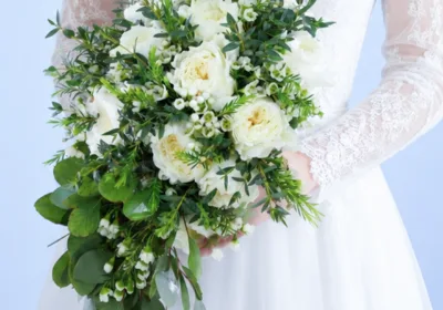 Luxe White Floral Bouquet featuring white garden roses, white wax flowers, and fresh greenery in an elegant bridal arrangement