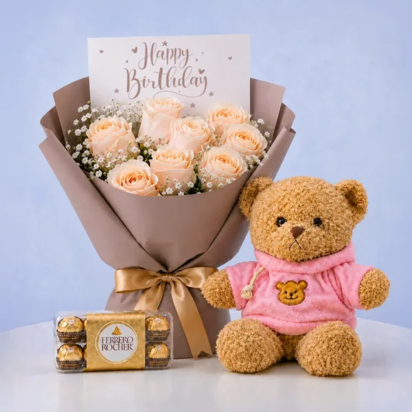 birthday-rose-teddy-combo Birthday Rose Teddy Combo featuring peach roses, gypsophila, 16 Ferrero chocolates, and a 40cm pink jacket teddy bear for gifting and celebrations.