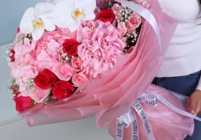 Grand Pink Luxury Bouquet featuring pink hydrangeas, red roses, light pink roses, pink ping pong blooms, phalaenopsis orchid, and fresh gypsophila arranged in a luxurious floral bouquet for elegant gifting.