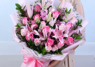 Luxury Pink Flower Bouquet featuring pink lilies, pink matthiola, pink roses, light pink roses, wax flowers, and fresh ruscus foliage arranged in an elegant mixed floral bouquet for gifting and celebrations.