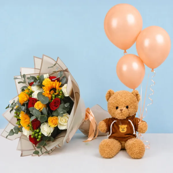 Mixed Blooms Teddy Combo featuring white, red, and yellow roses, sunflowers, eucalyptus, hypericum berries, a brown hoodie teddy bear, peach balloons, and premium floral wrapping.