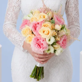 Dreamy Blush Wedding Bouquet featuring pink roses, peach spray roses, white ranunculus, and blush astilbe in a romantic bridal arrangement