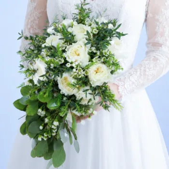 Luxe White Floral Bouquet featuring white garden roses, white wax flowers, and fresh greenery in an elegant bridal arrangement