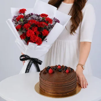 Red Bliss Cake Combo featuring red carnations, wax flowers, and a 1kg double chocolate cake for gifting and celebrations